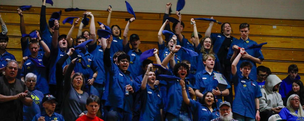 Robotics Team from the FIRST Robotics GVSU District Event cheering on their team -- all wearing their team's blue tshirts.